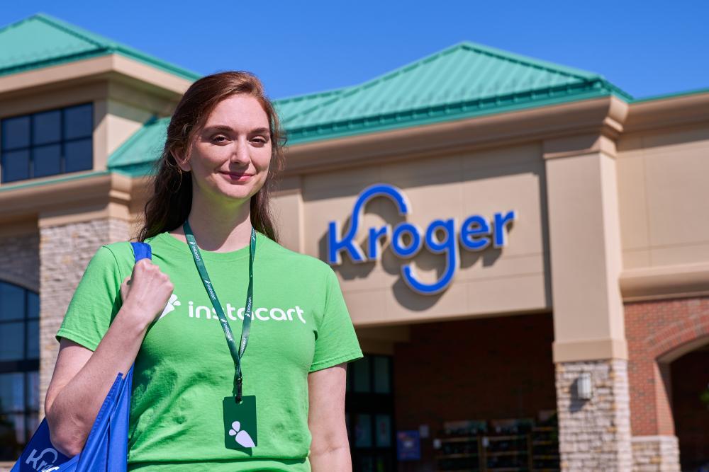 a person wearing a green shirt standing in front of a building