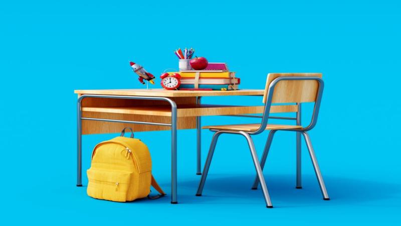 School desk and chair with backpack and supplies