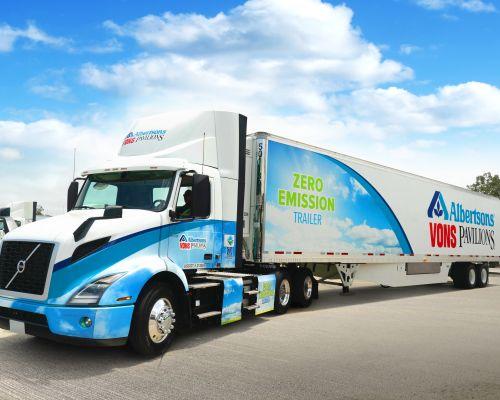 a large blue truck is parked on the side of a road